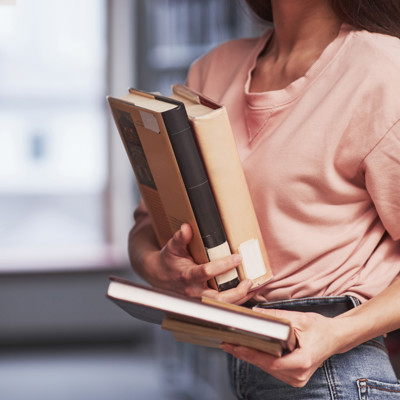 Woman Carrying Stack Of Books